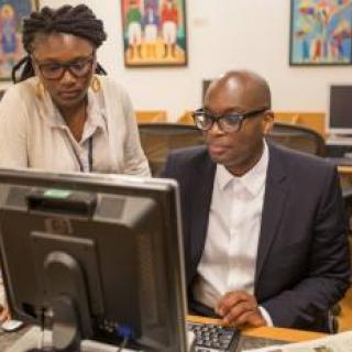 Two people at a library computer.