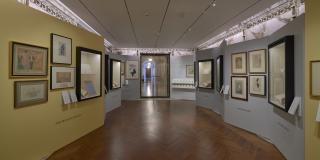 Photograph with fisheye view of exhibition showing both sides of the gallery corridor