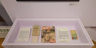 Close up image of archival materials in a lavender wall hanging display case