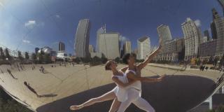 Two dancers in a pose in front of Cloud Gate in Millennium Park, Chicago.