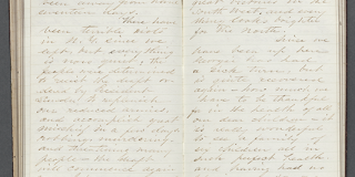 Photograph of an open diary, with a two-page spread featuring lined paper with cursive script writing