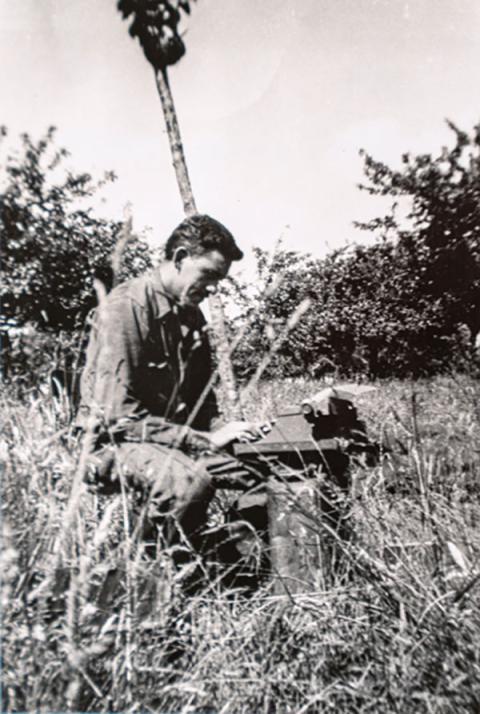 J.D. Salinger writing on his typewriter in a field