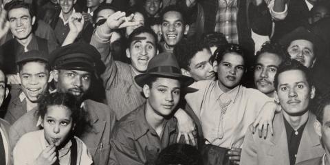 A black and white archival picture of a group of people who are looking towards the camera.