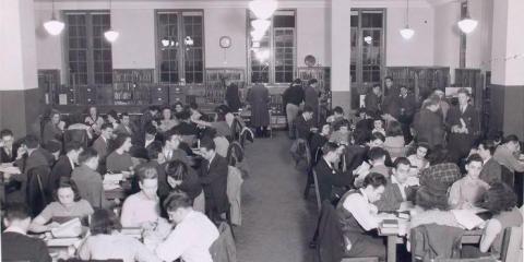 Black and white photograph of a library room packed with young adults. A caption notes: Student attendance is over 50,000 annually.