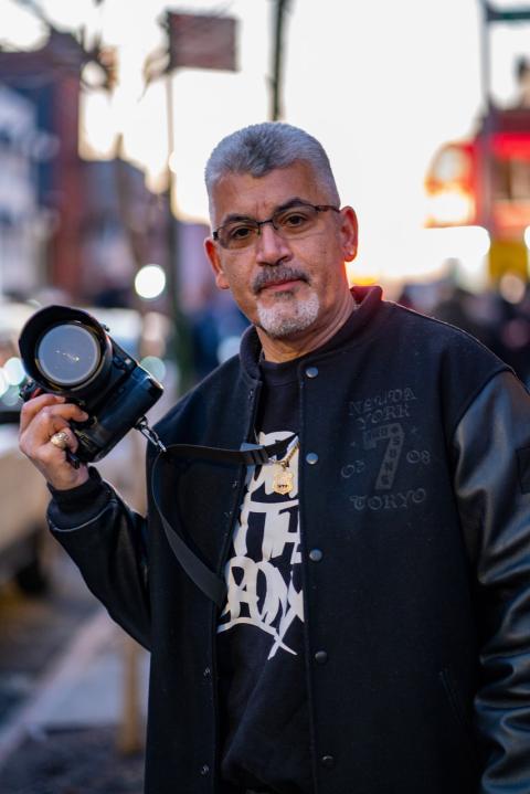 A portrait of Joseph Conzo holding a camera. 